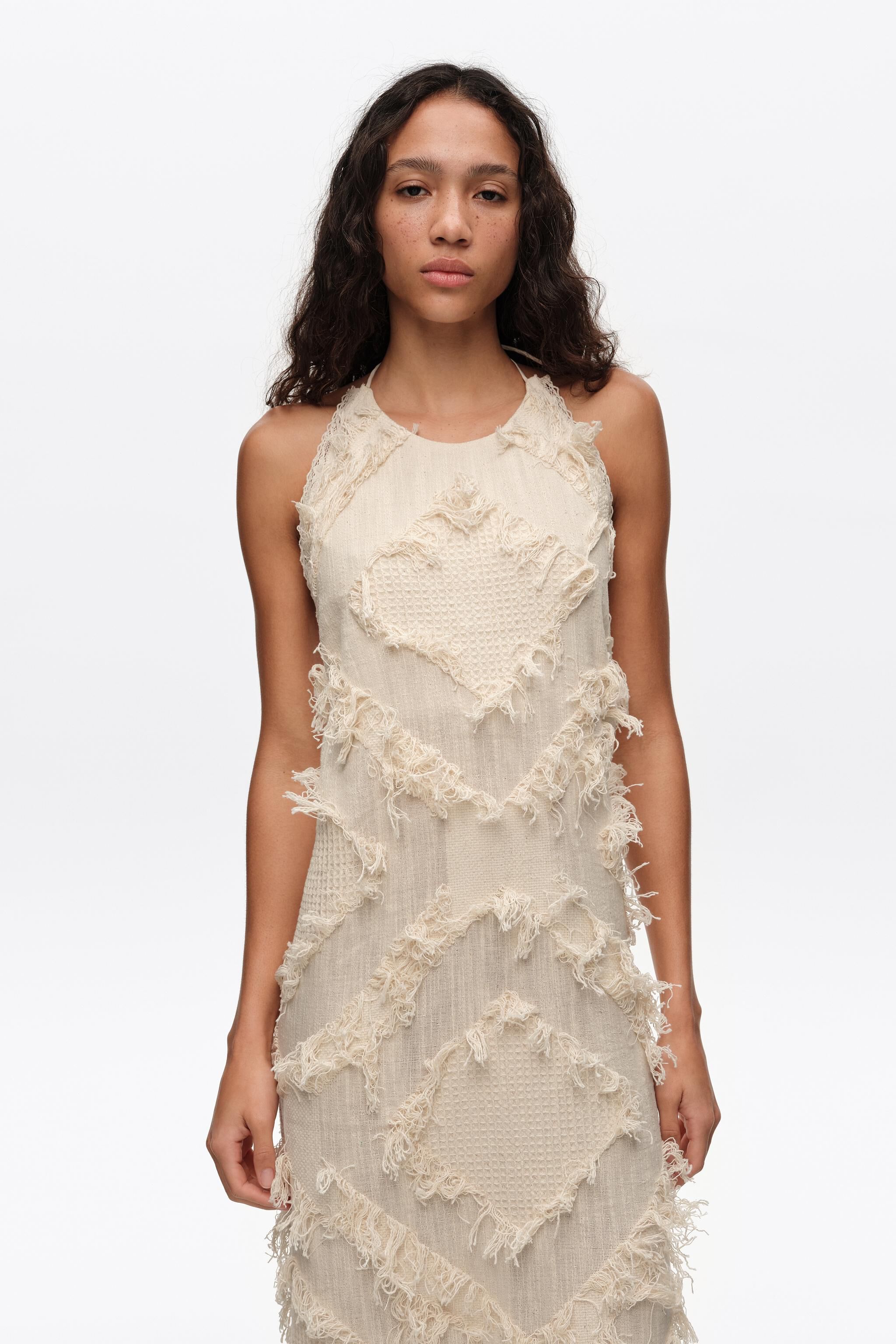 Vestido de cuello halter de color marfil con flecos