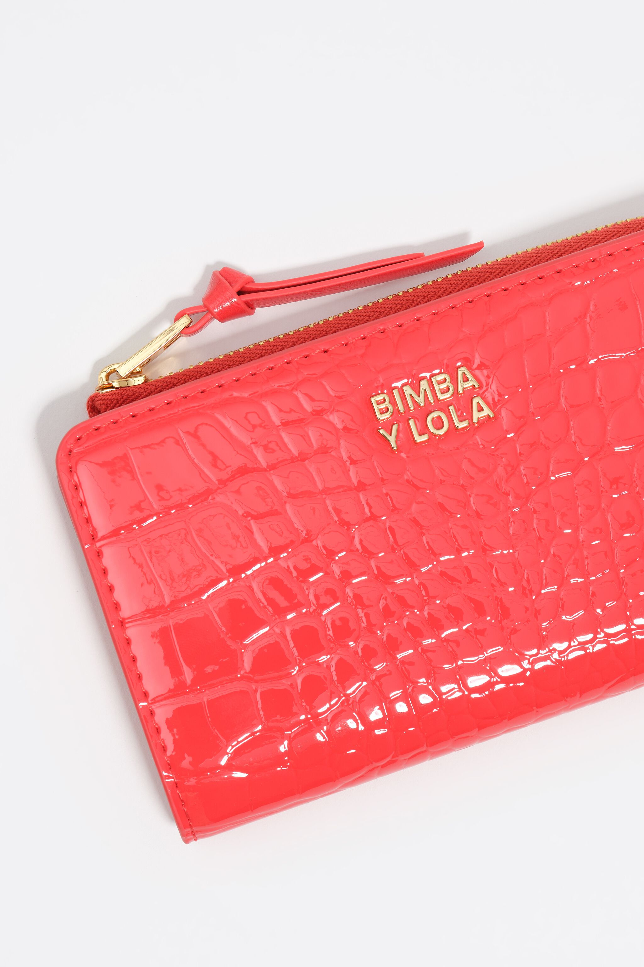 Monedero compacto de cuero sintético con efecto cocodrilo coral