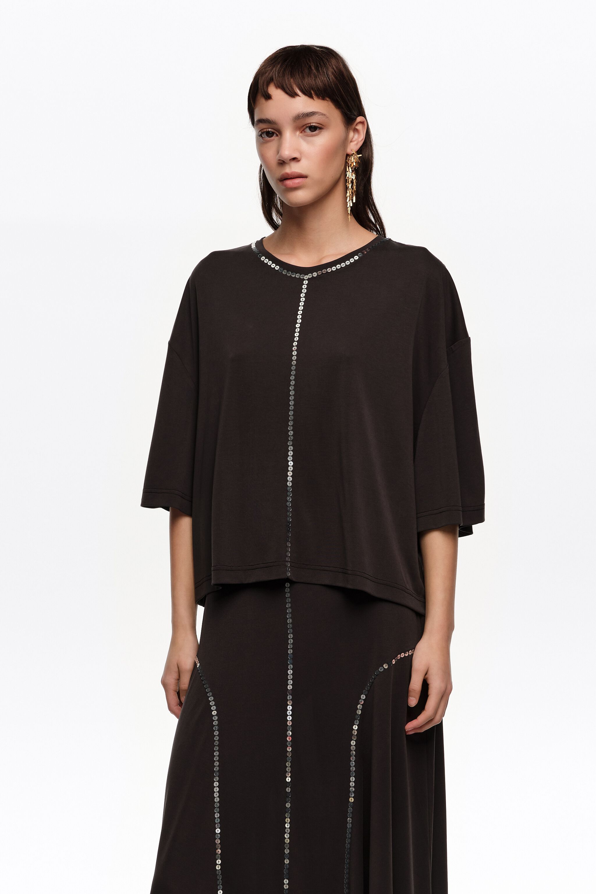 Camiseta negra fluida desgastada con lentejuelas