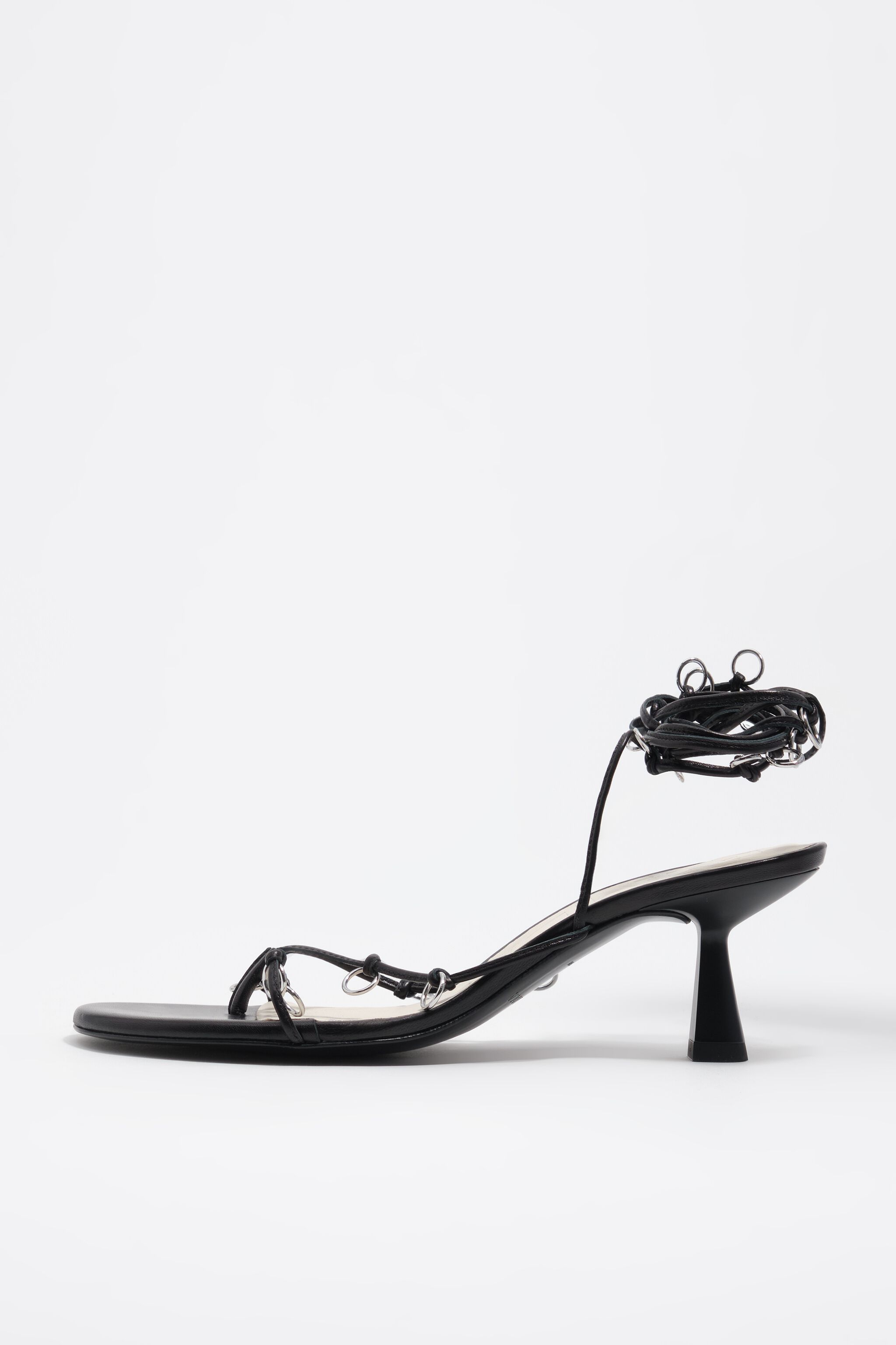 Sandalia de cuero negro con tacón y agujeros decorativos