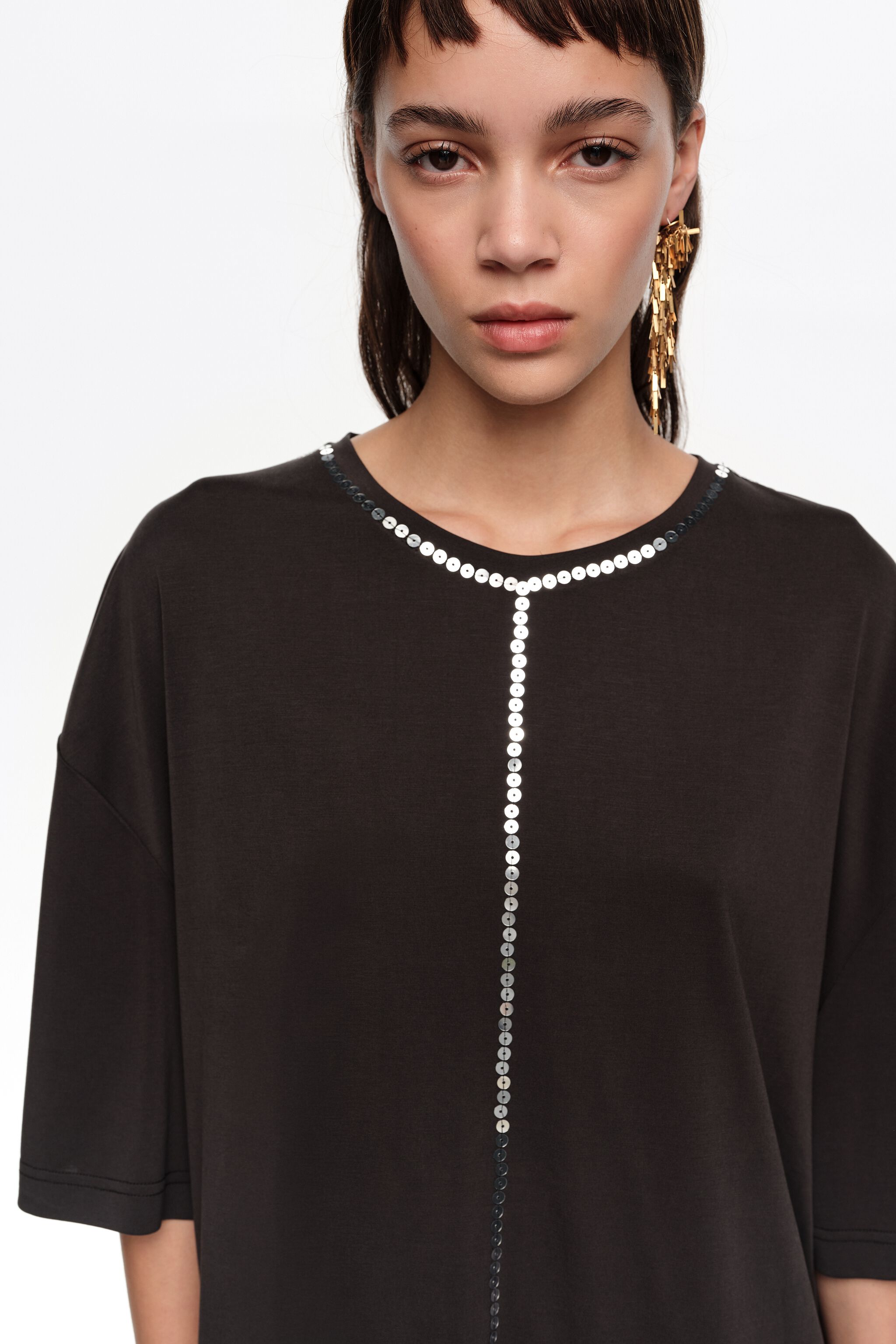 Camiseta negra fluida desgastada con lentejuelas