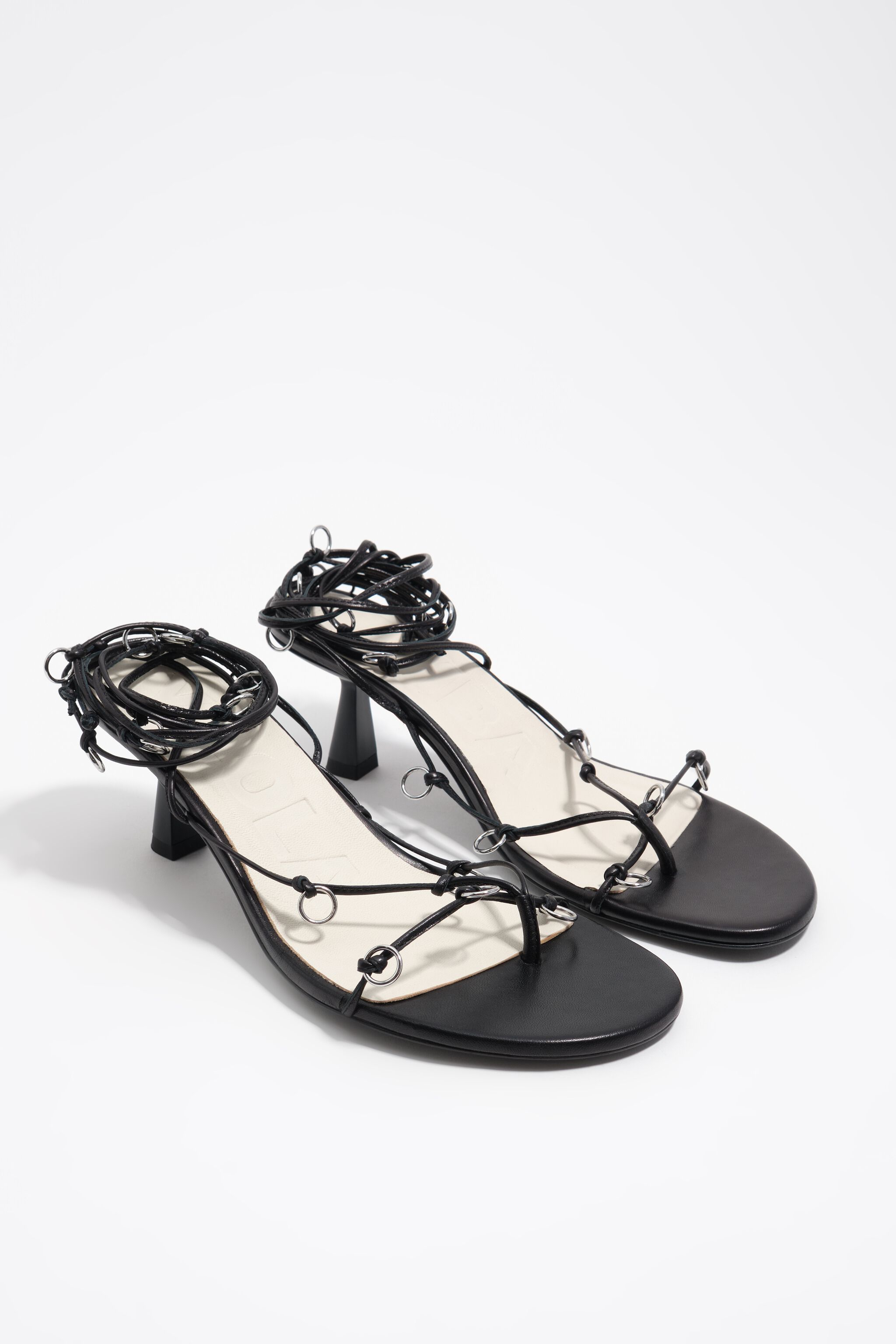 Sandalia de cuero negro con tacón y agujeros decorativos