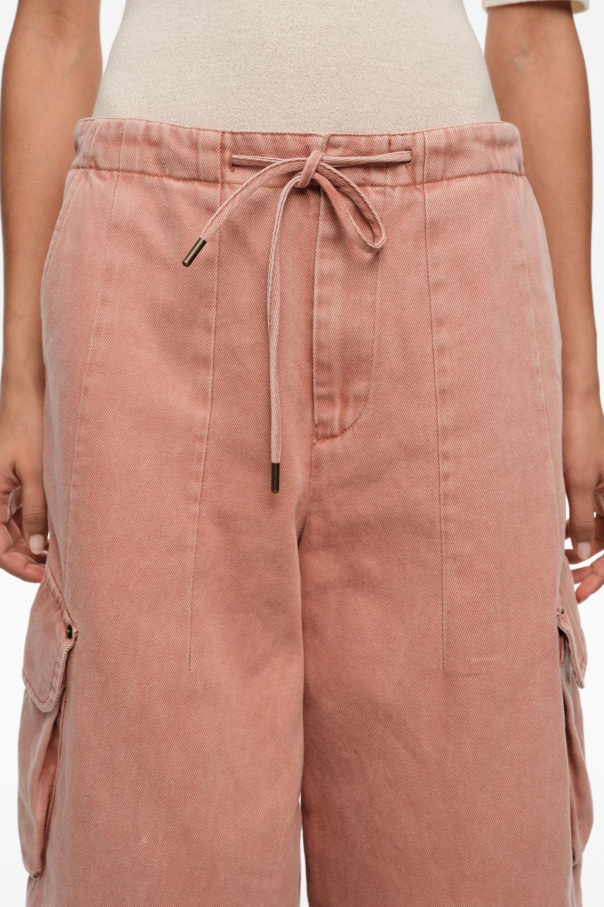 Pantalones de denim tipo cargas con color melocotón